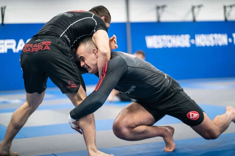 No gi jiu jitsu training session with athletes wearing rash guards and grappling shorts